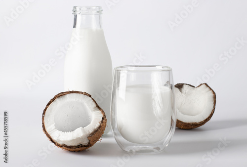 Fresh coconut, coconut milk in a bottle and glass on a white background. Vegan and vegetarian food.