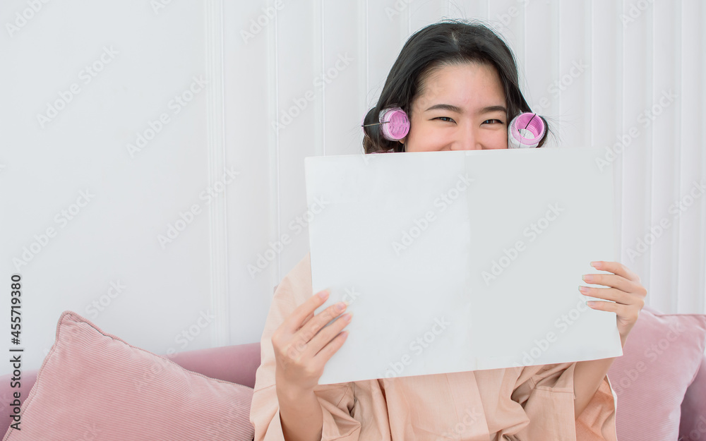 Portrait of asian beautiful woman rolling her hair, wearing bathrobe and reading book at home. Beauty & Lifestyle Concept. Portrait of asian beautiful woman rolling her hair, wearing bathrobe and reading book at home. Beauty & Lifestyle Concept.