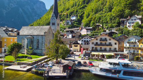 HALLSTATT, AUSTRIA - SEPTEMBER 3, 2021: Aerial view of the beautiful town from a flying drone over the lake in summer season.