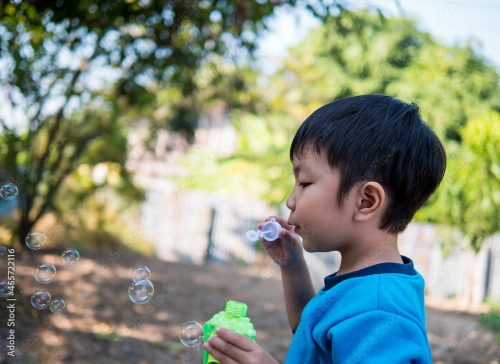 Asian child boy playing, blowing bubbles outdoor with happy face in nature garden background, bubbles in the air. Young kid have fun in relaxing holiday, freedom concept. Asian child boy playing, blowing bubbles outdoor with happy face in nature garden background, bubbles in the air. Young kid have fun in relaxing holiday, freedom concept.
