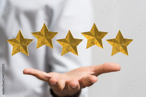 Customer hand touching to yellow illustration 5 stars virtual screening monitor for satisfaction evaluation