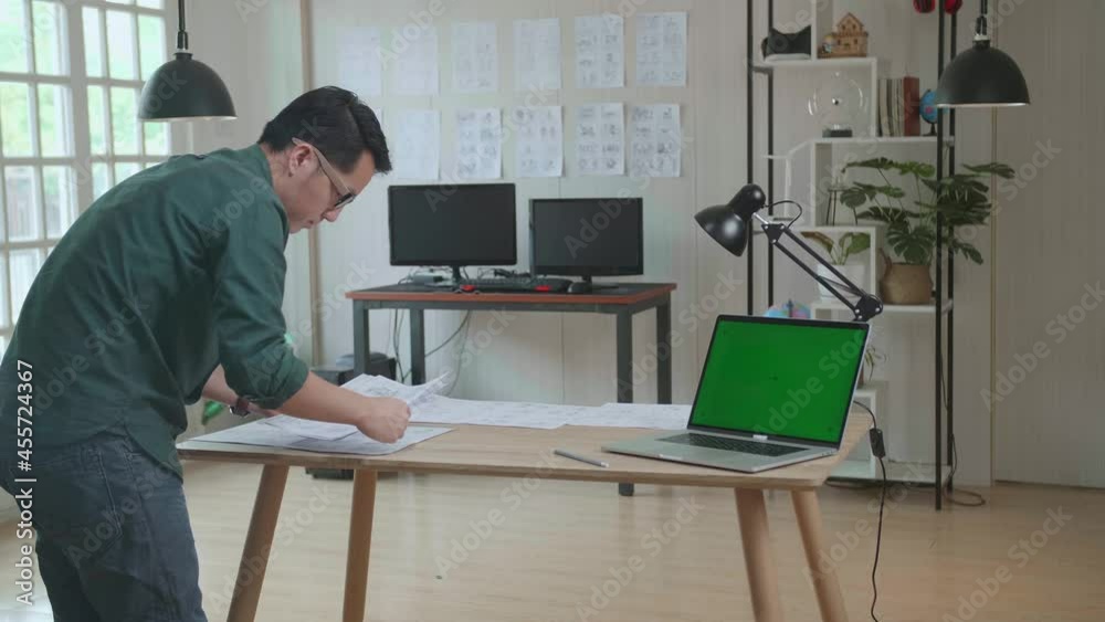 Creative Designer Works On A Storyboard, Looks At His Sketches With Mock Up Green Screen Laptop Computer, Choosing The Best Drawings For His Project, Comics Compilation, Application Ui Or Game Plot
Creative Designer Works On A Storyboard, Looks At His Sketches With Mock Up Green Screen Laptop Computer, Choosing The Best Drawings For His Project, Comics Compilation, Application Ui Or Game Plot
