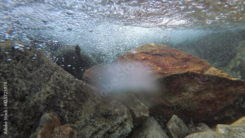 Mountain river, underwater video. The bottom, stones and bubbles, clear water in the river photo