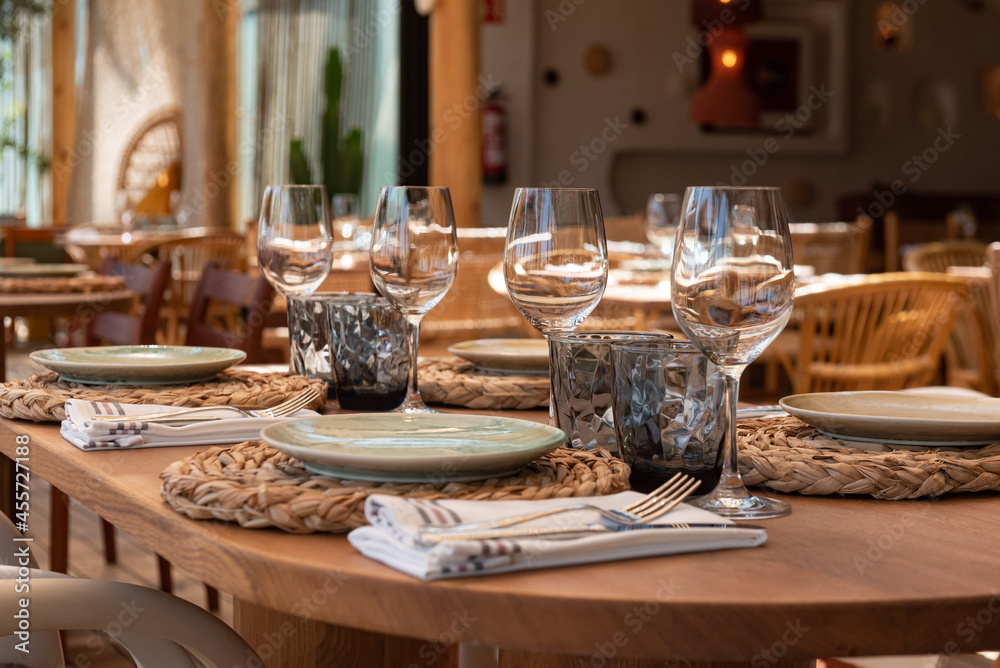 Mesa de restaurante turístico en la playa con copas, vasos, platos y cubertería  completa Photos