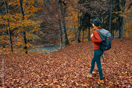 woman hiker walking in the autumn forest travel fresh air