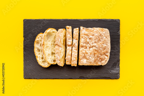 Freashly backed bread slice on cutting board, top view photo