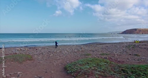 Aerial: Surfer entering the water at Pacifica, San Francisco