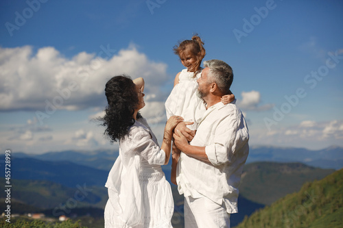 Grandparents in summer mountains with granddaughter