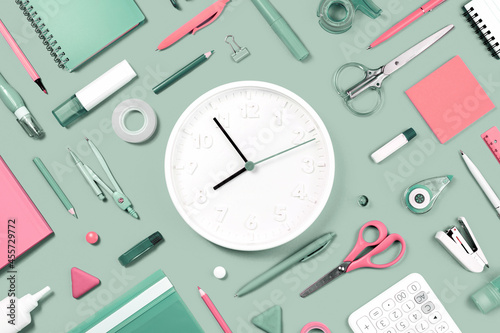 Assorted office and school whitepink and olive green stationery supply on pastel trendy background as knolling. White clock. Flat lay for back to school or education and craft concept. photo