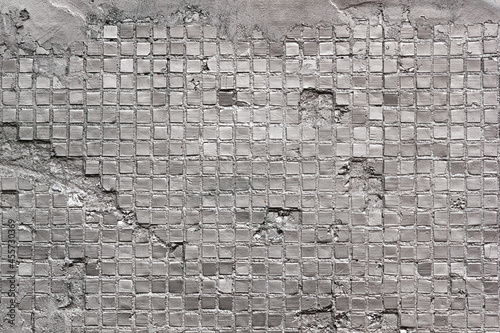 Abstract tiled wall, horizontal background in the form of a rough damaged old wall, closeup