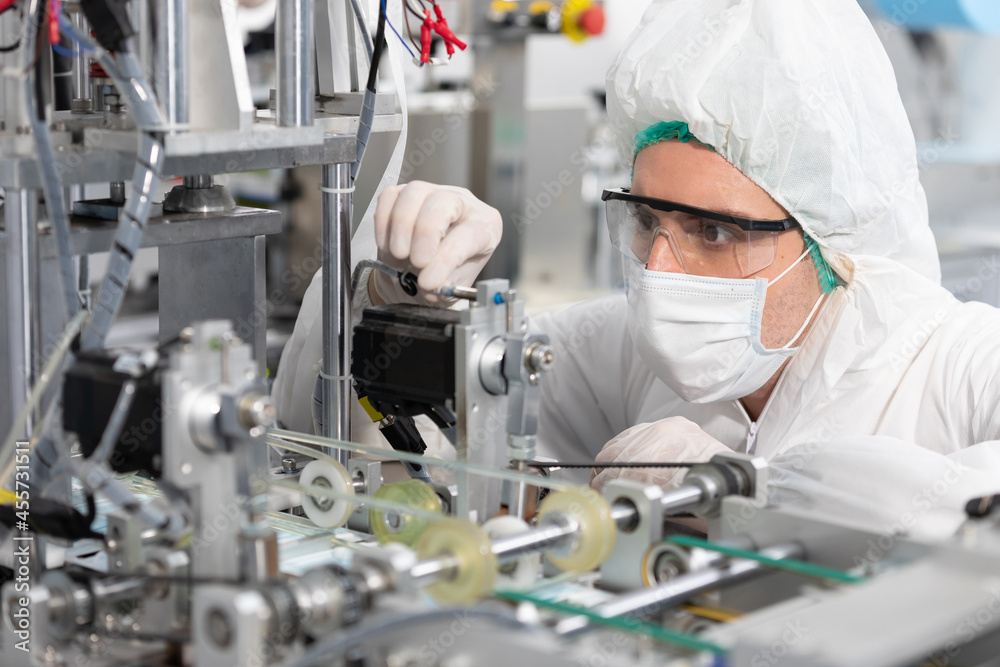 male engineers wearing personal protective equipment uniform(PPE) and medical face mask, checking machine in laboratory male engineers wearing personal protective equipment uniform(PPE) and medical face mask, checking machine in laboratory