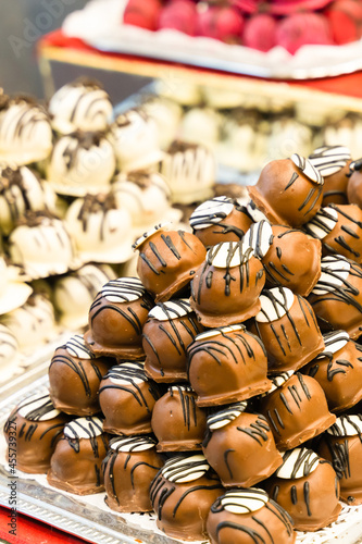sweets covered with chocolate glaze with white pattern stacked stack on blurred background