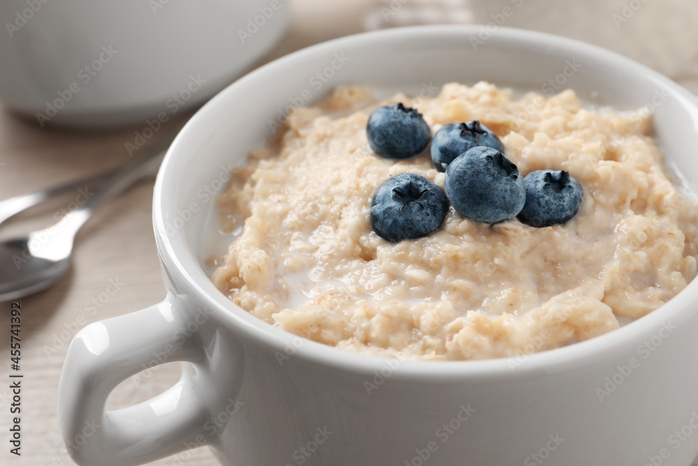 Tasty oatmeal porridge with blueberries in bowl on table, closeup Tasty oatmeal porridge with blueberries in bowl on table, closeup