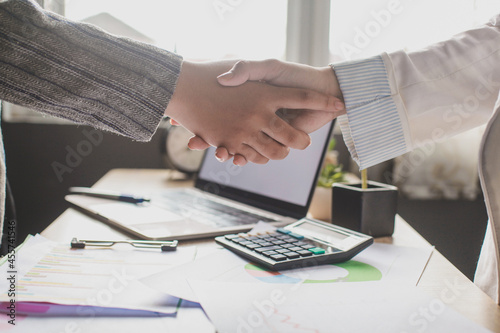 Two people handshaking in an office photo