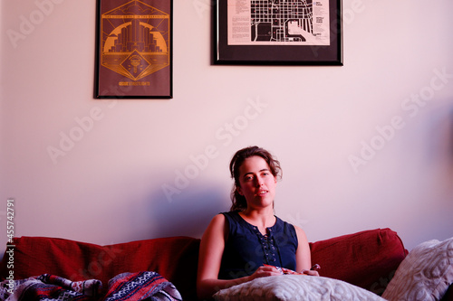 Woman sitting on red couch in living room photo