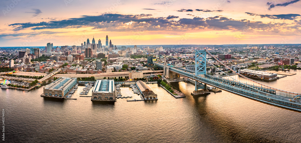 Aerial panorama with Ben Franklin Bridge and Philadelphia skyline at sunset. Ben Franklin Bridge is a suspension bridge connecting Philadelphia and Camden, NJ.