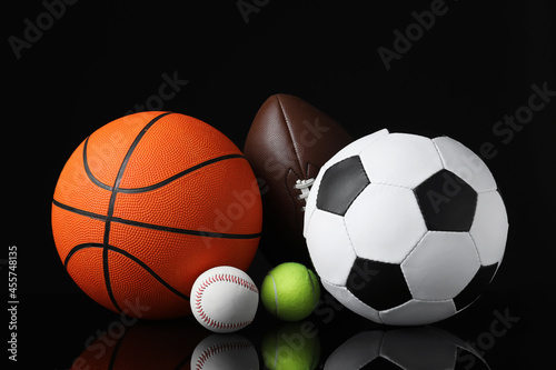 Set of different sport balls on black mirror surface