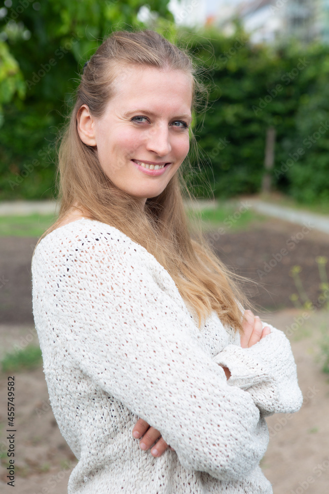 portrait of young blond woman standing outside and smiling portrait of young blond woman standing outside and smiling