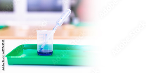 Microscopy and used laboratory glasses for the microscope are on a green tray after the study. results of clinical trials. laboratory studies of drugs, blood and vaccines