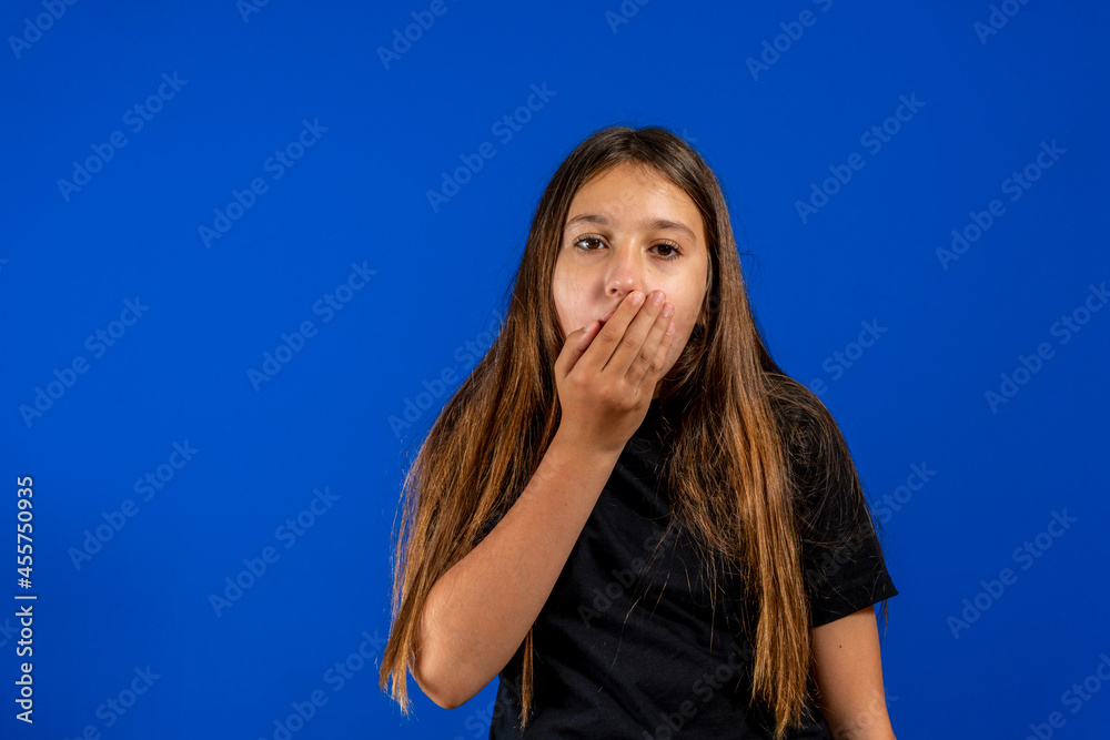Close-up studio shot of beautiful brunette little girl posing against a blue background. Close-up studio shot of beautiful brunette little girl posing against a blue background.