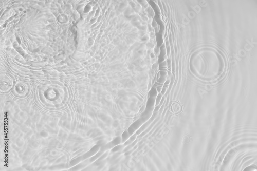 Water tranquil ripple background. Water texture, circles and bubbles on a liquid white surface. Cosmetic products and flat design concept