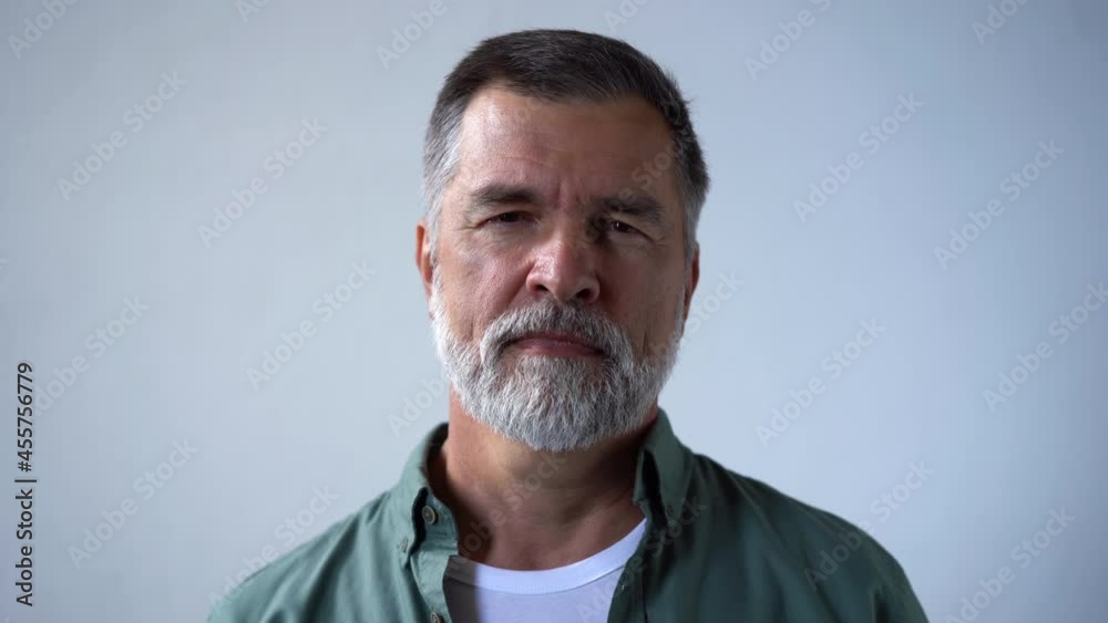 Friendly looking retired senior man taking off his glasses and smiling cheerfully while looking into the camera Friendly looking retired senior man taking off his glasses and smiling cheerfully while looking into the camera