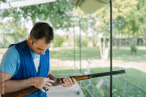 Mid Adult Man Training His Aim and Concentration Using a Shotgun in a Clay Pigeon Shooting Field Sport Centre  photo