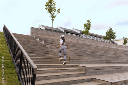 A woman in sportswear runs up the wooden steps
