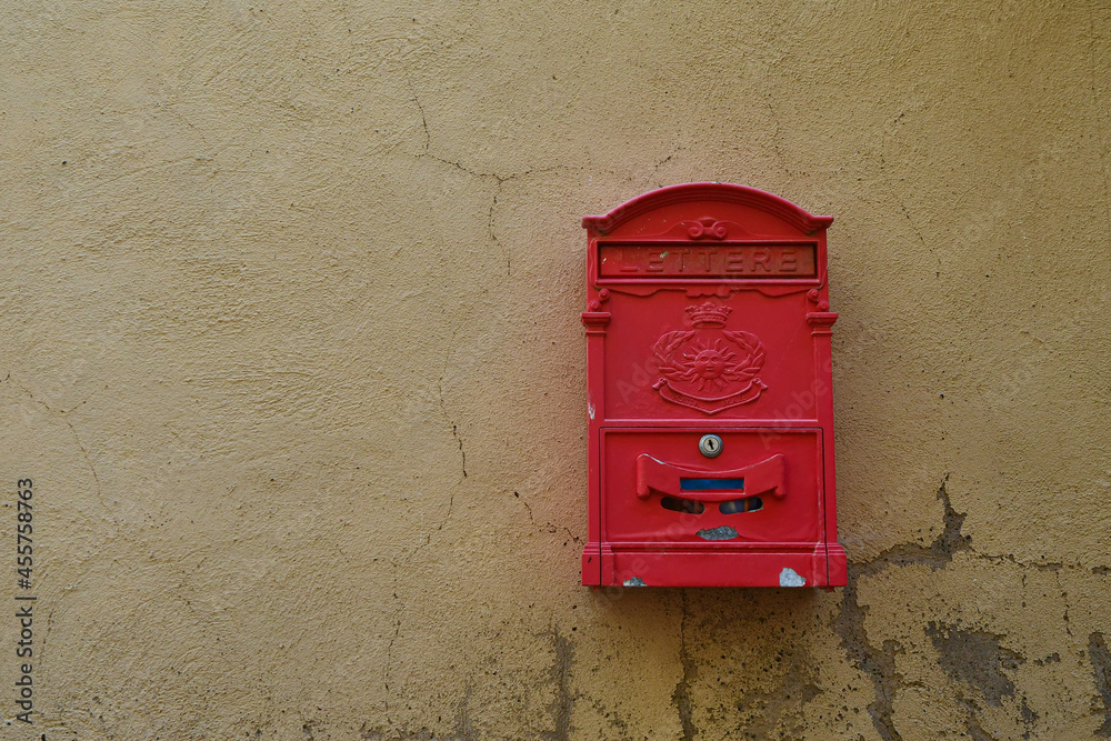 Close-up of an old yellowish wall with a red mailbox, Tuscany, Italy