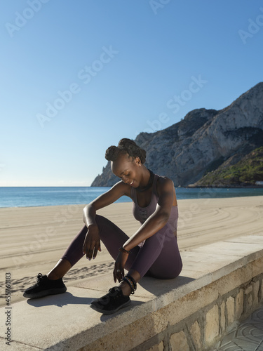 Cheerful black sportswoman taking break photo