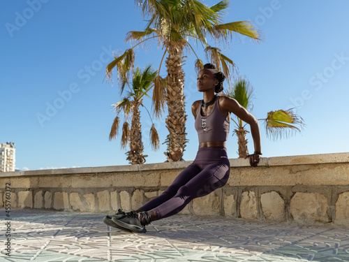 Strong sportswoman exercising on tropical beach photo