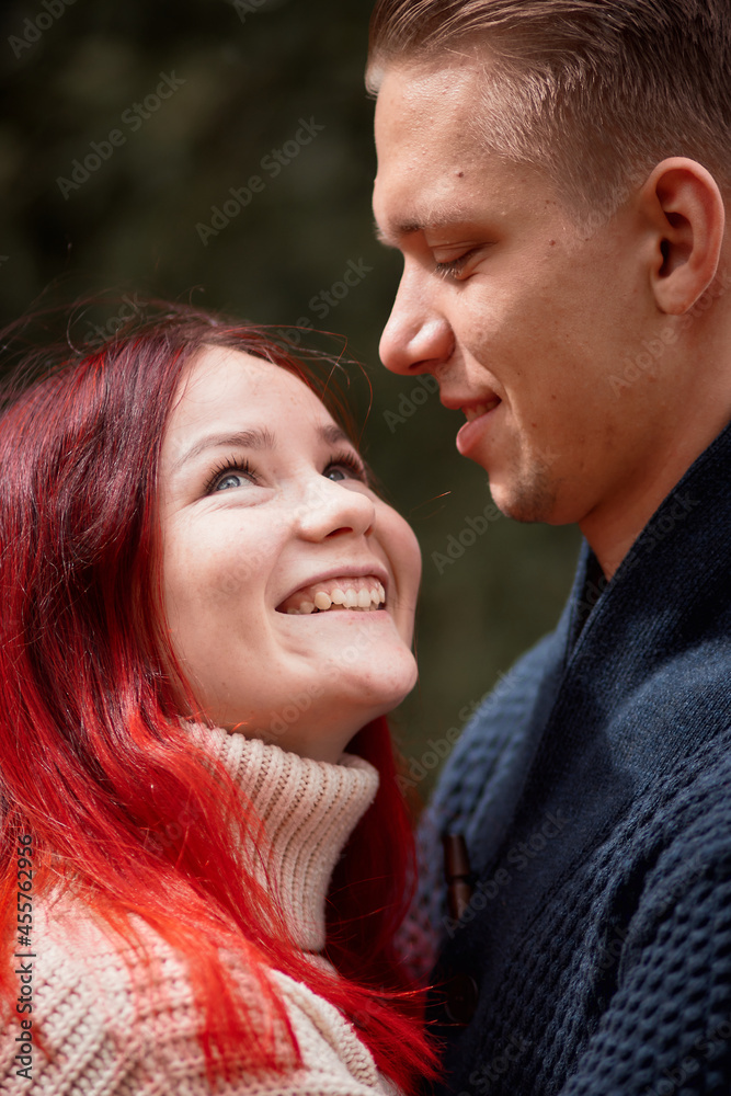Loving couple of young people having fun on nature, young girl with red hair Loving couple of young people having fun on nature, young girl with red hair