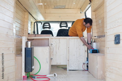 Man Installing Solar Charge Converter in Motorhome photo