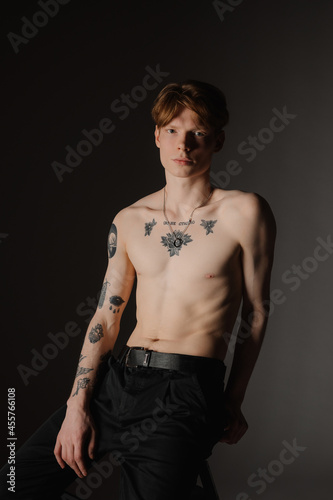 Shirtless tattooed man in dim studio photo