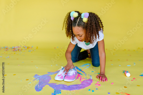 Girl with pigtails fingerpainting shoes photo