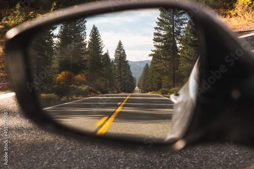 Side view mirror of car with reflection of road photo