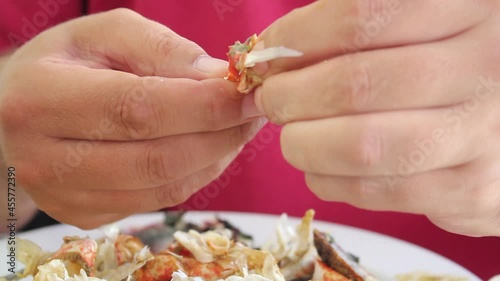 Man eating a red crab with his hands