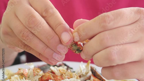 Man eating a red crab with his hands
