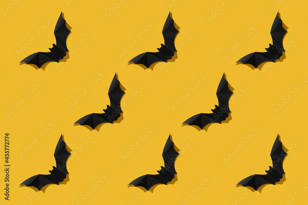 Black paper bat on a white background. Halloween concept. With a hard black shadow. View from above.