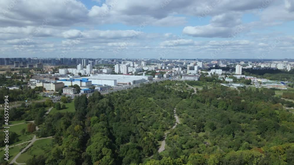City landscape. Nearby there is a park area. Blue sky with white clouds. Aerial photography. City landscape. Nearby there is a park area. Blue sky with white clouds. Aerial photography.