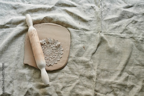 master craftsman rolls the clay on the table, transfers the napkin pattern to the clay mass