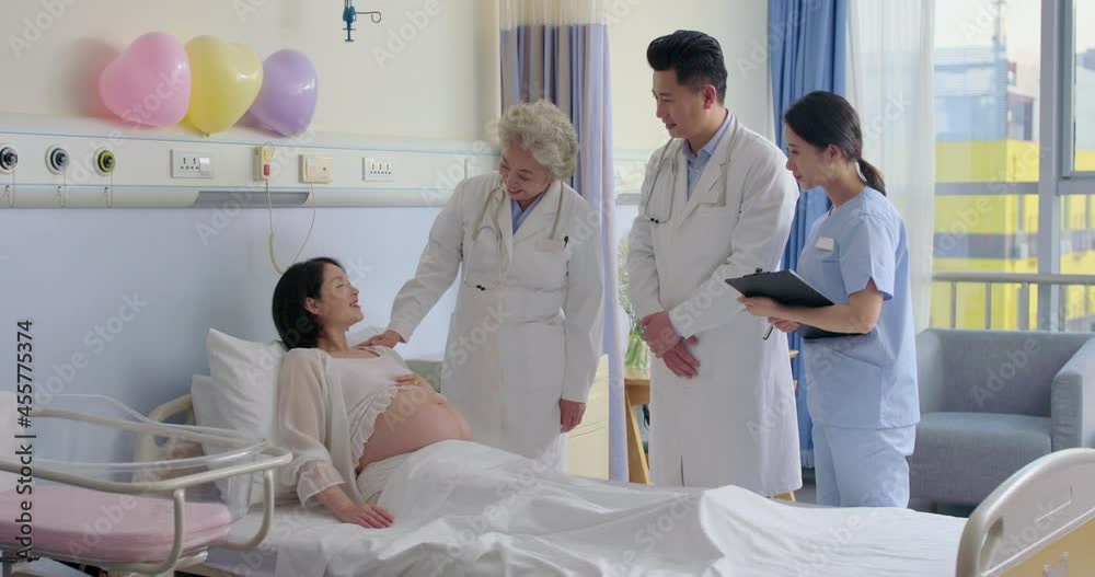 Doctor examining pregnant woman in hospital ward,4K