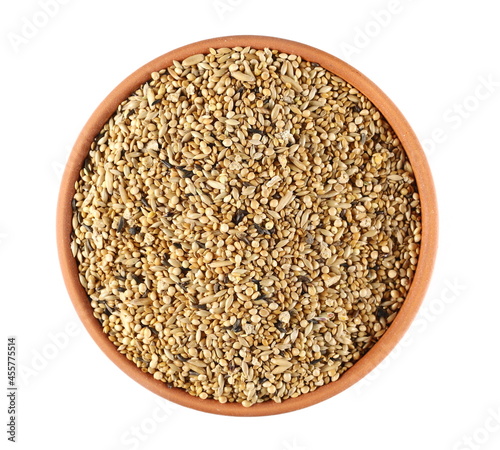 Mixed bird seeds in bowl, millet, niger seed surface background and texture, top view