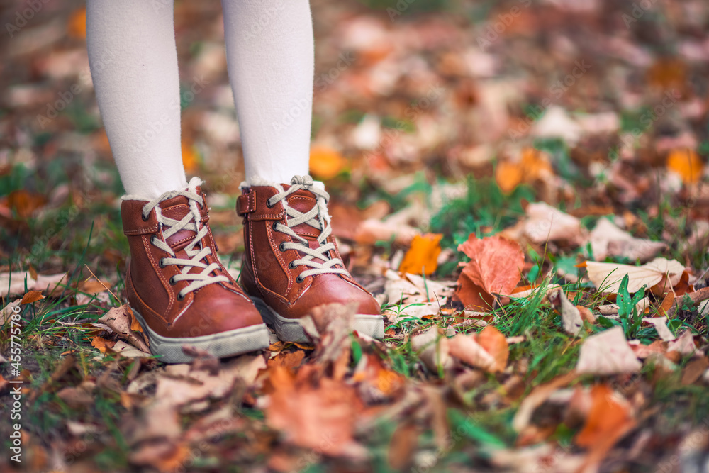 Children in the park with autumn leaves on shoes