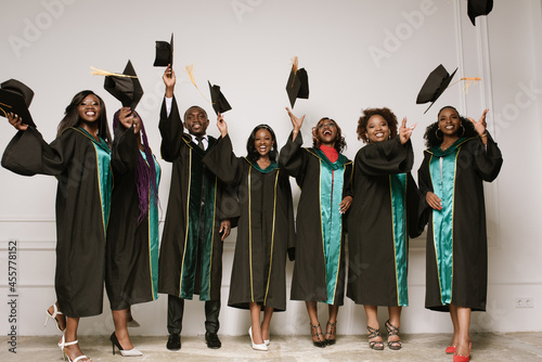 Happy students throw up their academic caps photo