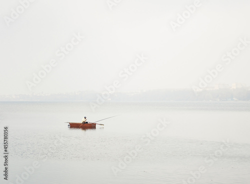 Canvastavla A lonely fisherman rows in a boat in the lake