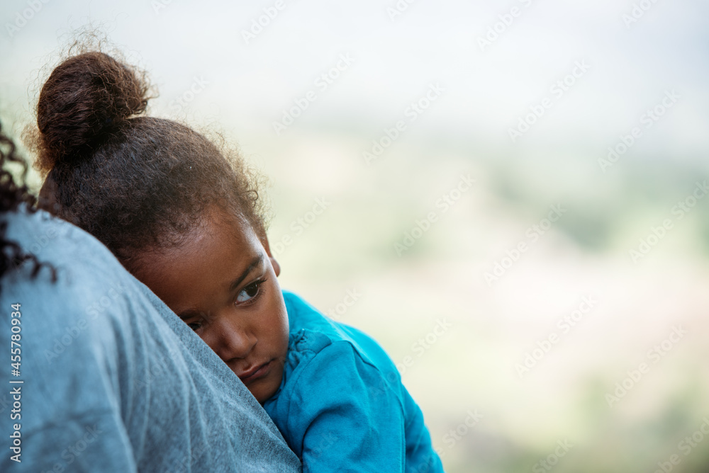 Cute little girl looking away while leaning in back of mother Cute little girl looking away while leaning in back of mother