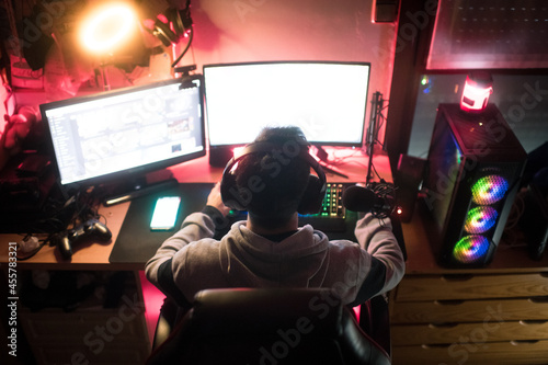 Back of a gamer in his bedroom with his setup photo