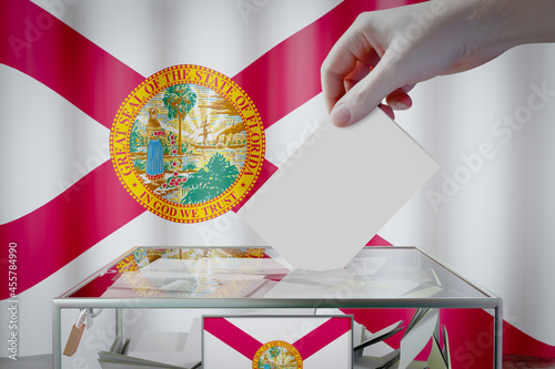 Florida flag, hand dropping ballot card into a box - voting, election concept - 3D illustration photo
