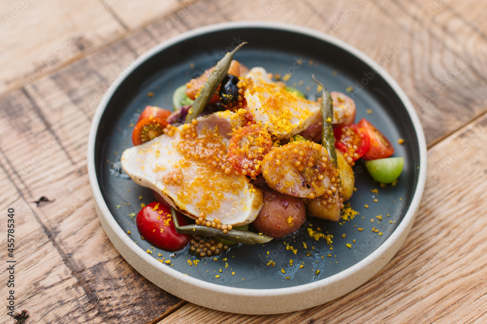 Plate of fresh nicoise salad on a rustic wooden table. Plate of fresh nicoise salad on a rustic wooden table.